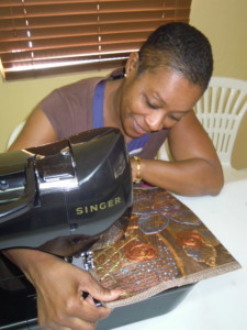 Sewing a painted clutch purse.